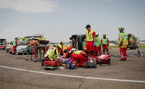 Strassenrettungsübung mit Beteiligung von Feuerwehrleuten und Rega-Personal an einem verunfallten Fahrzeug.