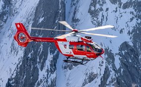 Rettungshelikopter im Flug in den Bergen im Winter