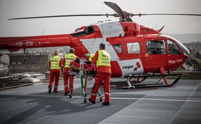 Ein Crew kehrt auf dem Landeplatz zum Helikopter zurück.