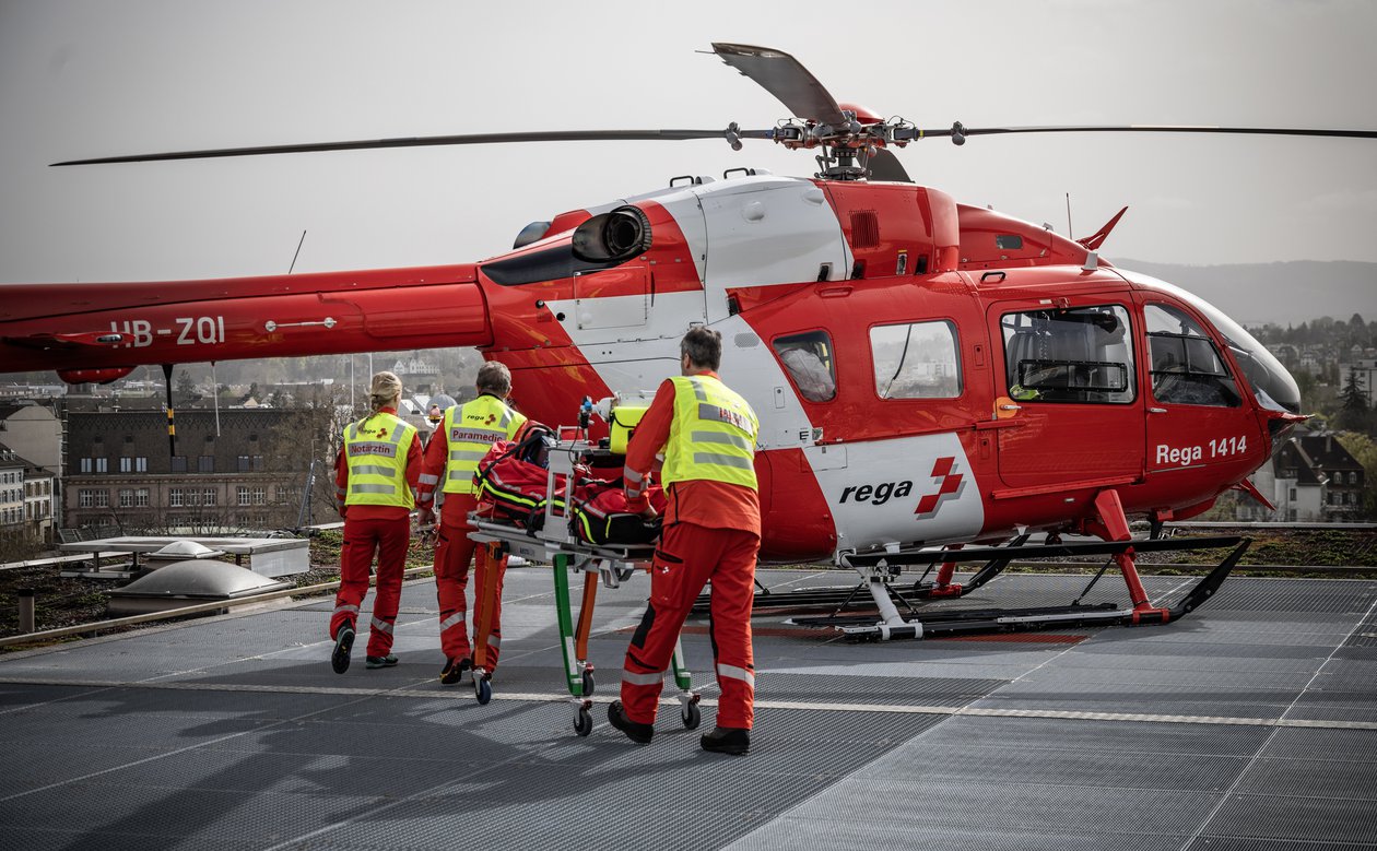 Ein Crew kehrt auf dem Landeplatz zum Helikopter zurück.