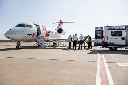 Zum Downloadformular für das Bild Rega-Crew lädt einen Patienten im Ausland in den Ambulanzjet ein.