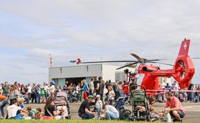 Rettungshelikopter und Besucherinnen und Besucher auf der Rega-Basis Basel
