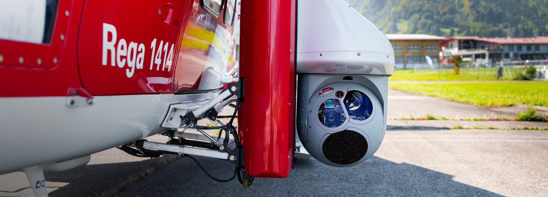 Nahaufnahme einer Wärmebildkamera an einem Rega-Helikopter. Auf dem Helikopter ist der Schriftzug «Rega 1414» zu sehen.