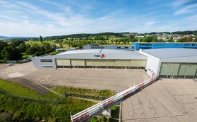 Aussenansicht des Rega-Centers am Flughafen Zürich mit den grossen Hangar-Toren und dem Landeplatz.