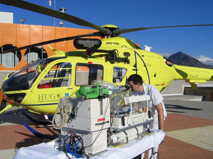 Photo symbole : L’isolette de transport et l’EC-135 de la base Rega-HUG de Genève (crédit photo HUG)